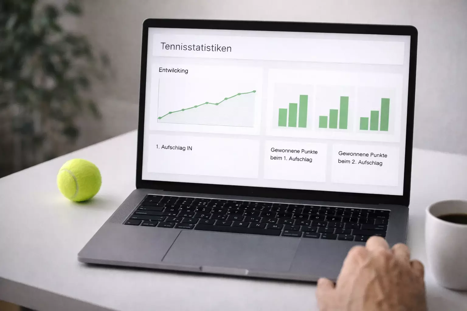 Laptop mit Statistiken und Tennisball auf Schreibtisch